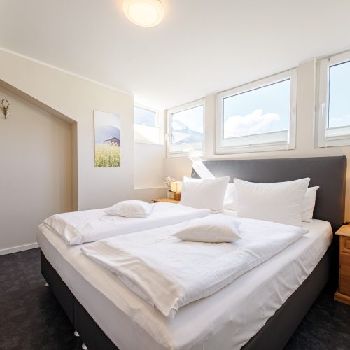 Doppelbett mit Nachttisch in Ferienwohnung in Garmisch-Partenkirchen