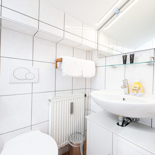 Badezimmer mit weißen Fliesen in Ferienwohnung in Garmisch-Partenkirchen