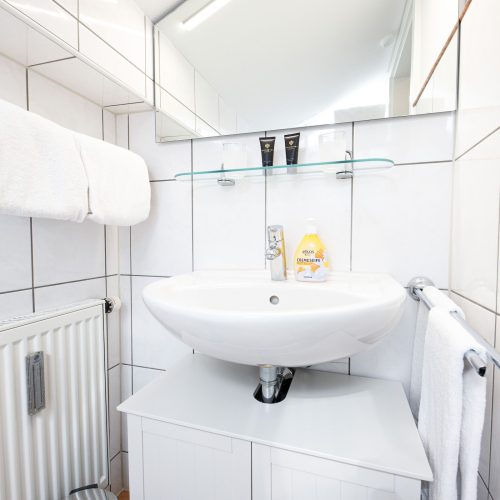 Badezimmer mit weißen Fliesen in Ferienwohnung in Garmisch-Partenkirchen