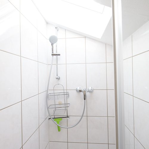 Dusche mit weißen Fliesen in Ferienwohnung in Garmisch-Partenkirchen
