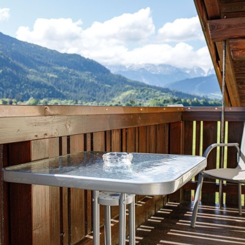 Balkon mit Stuhl und Tisch in Ferienwohnung in Garmisch-Partenkirchen