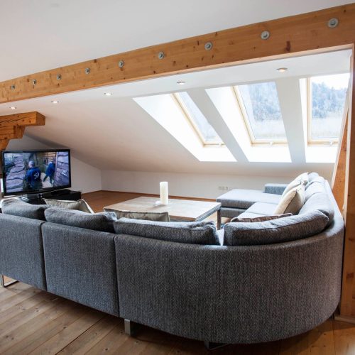 Sofa in grau mit Fernseher in Ferienwohnung in Garmisch-Partenkirchen