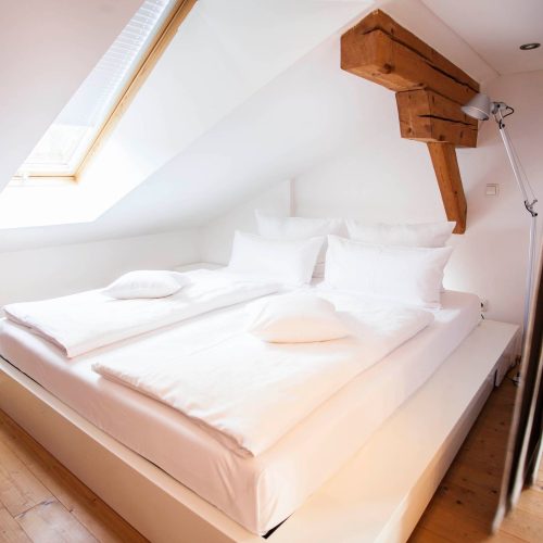 Doppelbett und Dachfenster in Ferienwohnung in Garmisch-Partenkirchen