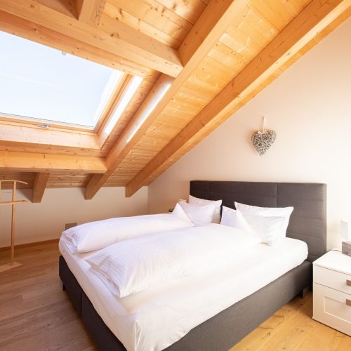 Doppelbett mit Dachfenster in Ferienwohnung in Garmisch-Partenkirchen