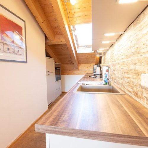 Küche mit brauner Arbeitsfläche in Ferienwohnung in Garmisch-Partenkirchen