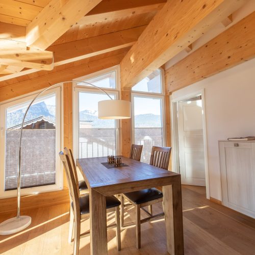 Tisch mit Stühlen und Stehlampe in Ferienwohnung in Garmisch-Partenkirchen