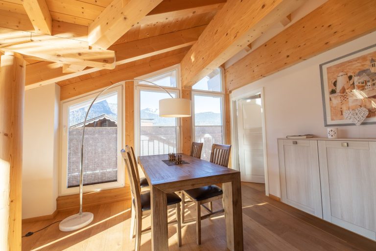 Tisch mit Stühlen und Stehlampe in Ferienwohnung in Garmisch-Partenkirchen