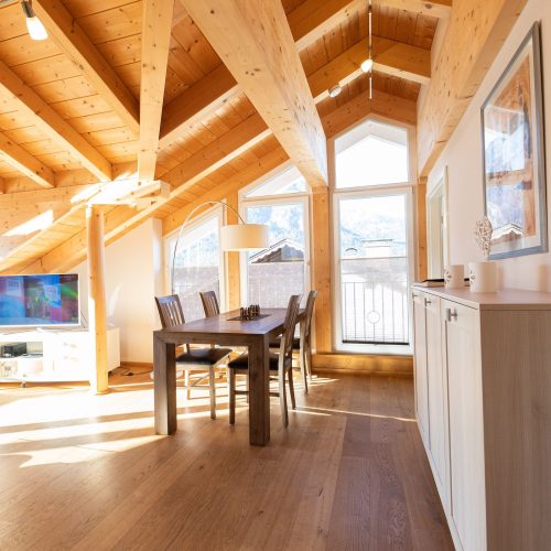 Tisch und Stühle mit Fernseher in Ferienwohnung in Garmisch-Partenkirchen