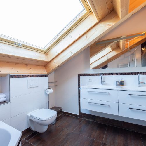 Badezimmer mit Spiegel und Waschbecken in Ferienwohnung in Garmisch-Partenkirchen