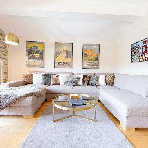 Wohnzimmer mit grauem Sofa in Ferienwohnung in Garmisch-Partenkirchen