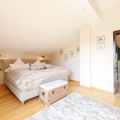 Doppelbett mit Hocker in Ferienwohnung in Garmisch-Partenkirchen