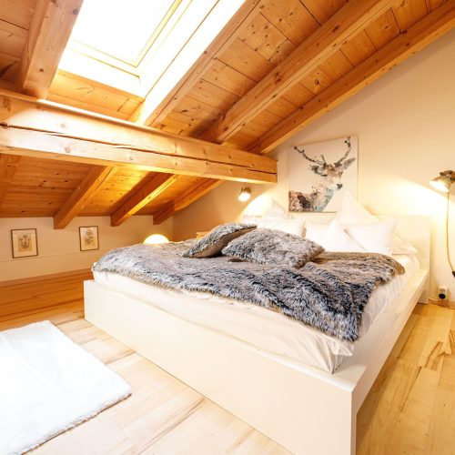 Doppelbett mit Dachfenster in Ferienwohnung in Garmisch-Partenkirchen