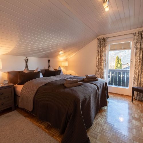 Doppelbett mit Gardienen in Ferienwohnung in Garmisch-Partenkirchen