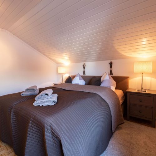 Doppelbett mit Nachttischlampen in Ferienwohnung in Garmisch-Partenkirchen