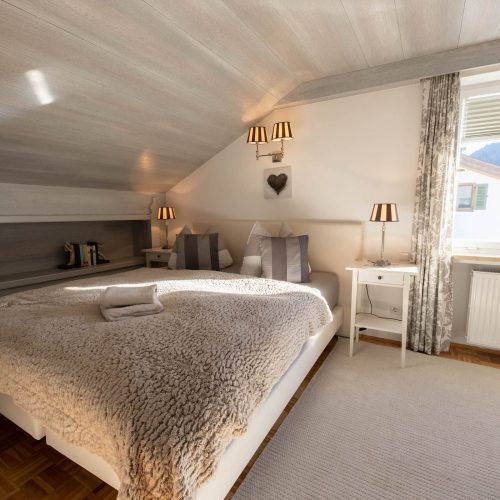 Doppelbett mit Felldecke in Ferienwohnung in Garmisch-Partenkirchen