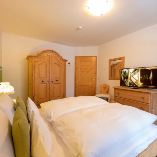 Doppelbett mit Fernseher in Ferienwohnung in Garmisch-Partenkirchen