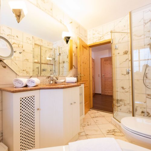 Badezimmer mit großem Spiegel und Dusche in Ferienwohnung in Garmisch-Partenkirchen