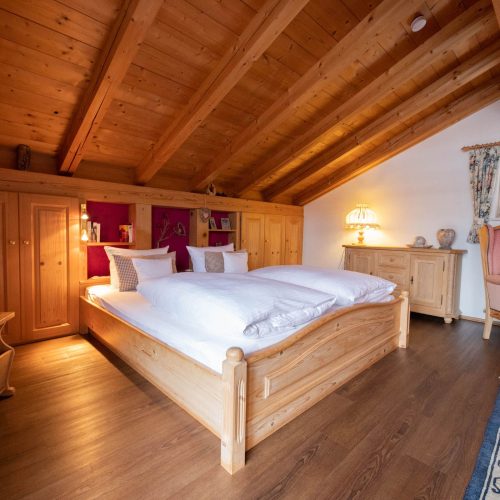 Doppelbett mit Sessel in Ferienwohnung in Garmisch-Partenkirchen