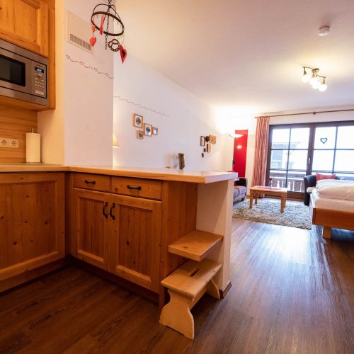 offene Küche und Wohnbereich mit Doppelbett in Ferienwohnung in Garmisch-Partenkirchen