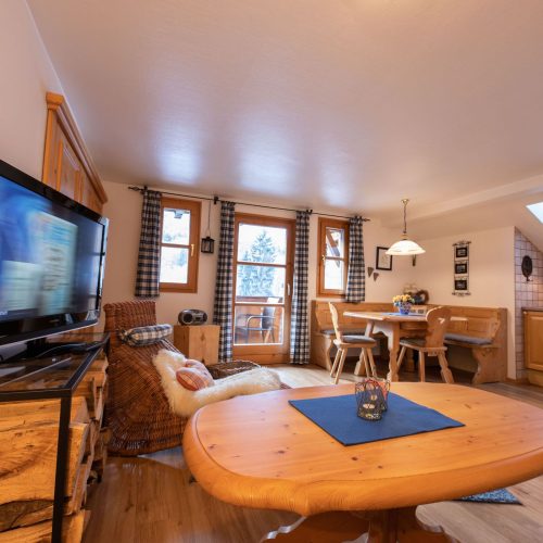 offener Wohnbereich mit Sessel und Fernseher in Ferienwohnung in Garmisch-Partenkirchen