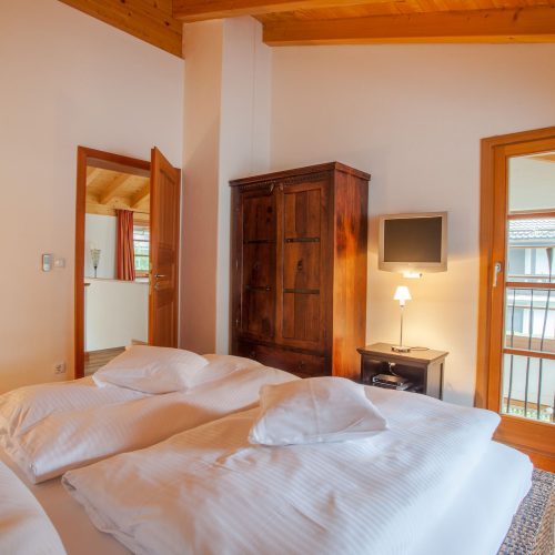 Doppelbett mit kleinem Fernseher in Ferienwohnung in Garmisch-Partenkirchen