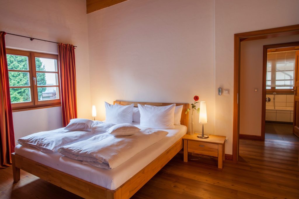 Doppelbett mit Nachttisch in Ferienwohnung in Garmisch-Partenkirchen