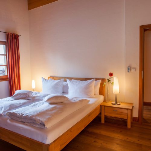 Doppelbett mit Nachttisch in Ferienwohnung in Garmisch-Partenkirchen