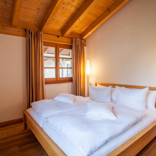 Doppelbett mit Stehlampe in Ferienwohnung in Garmisch-Partenkirchen