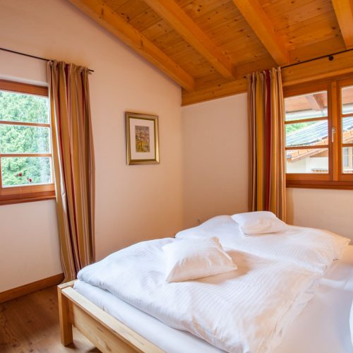 Doppelbett und Gardinen in Ferienwohnung in Garmisch-Partenkirchen