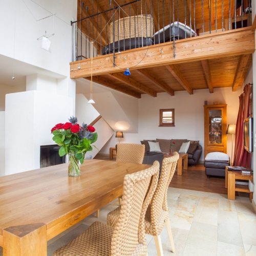 Esstische mit Blumen und offene erste Etage in Ferienwohnung in Garmisch-Partenkirchen