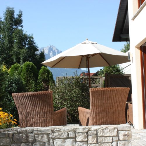 Terrasse mit Stühlen und Sonnenschirm in Ferienwohnung in Garmisch-Partenkirchen