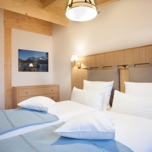 zwei Einzelbetten mit Kommode in Ferienwohnung in Garmisch-Partenkirchen