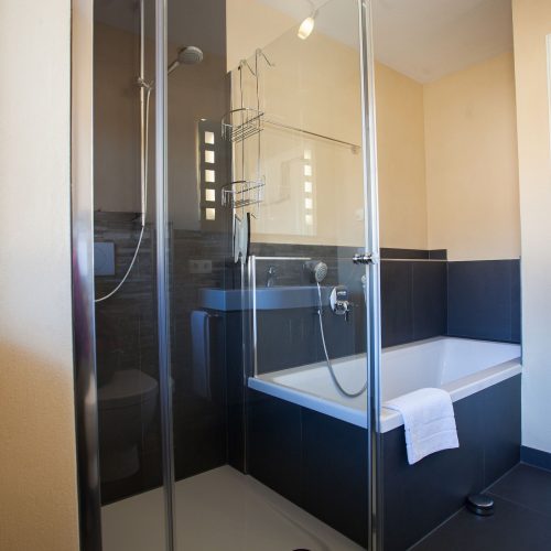 Badezimmer mit Dusche und Badewanne F