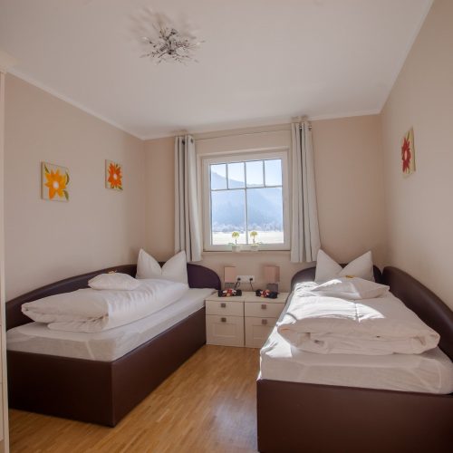 zwei Einzelbetten mit Kleiderharken in Ferienwohnung in Garmisch-Partenkirchen