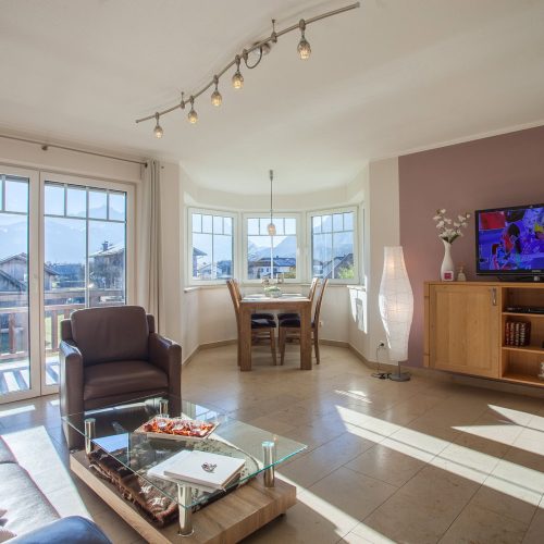 Wohnbereich mit Esstisch und Sofa mit Fernseher in Ferienwohnung in Garmisch-Partenkirchen