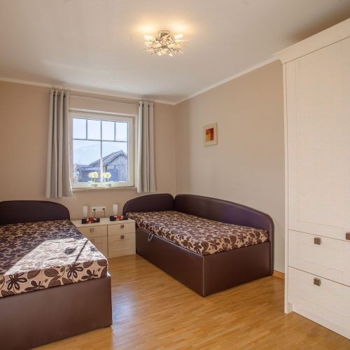 zwei Einzelbetten und Nachttischen in Ferienwohnung in Garmisch-Partenkirchen