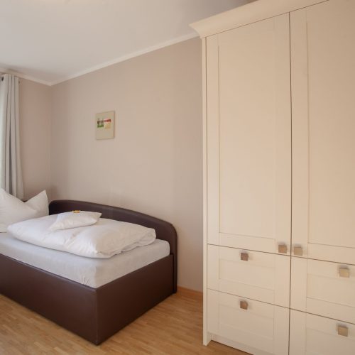 Einzelbett und Kleiderschrank in Ferienwohnung in Garmisch-Partenkirchen