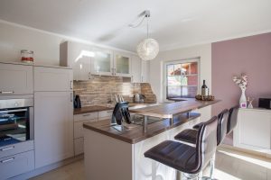 Küche mit Barhocker und Fenster in Ferienwohnung in Garmisch-Partenkirchen