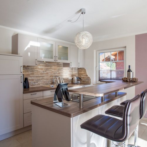 Küche mit Barhocker und Fenster in Ferienwohnung in Garmisch-Partenkirchen