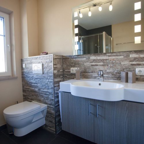 Badezimmer mit Spiegel und Waschbecken in Ferienwohnung in Garmisch-Partenkirchen