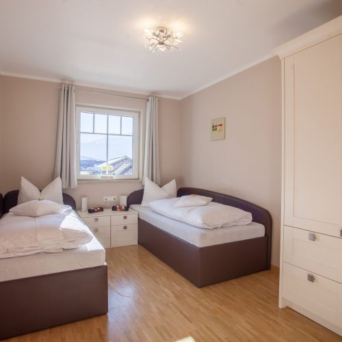 zwei Einzelbetten und Nachttisch in Ferienwohnung in Garmisch-Partenkirchen