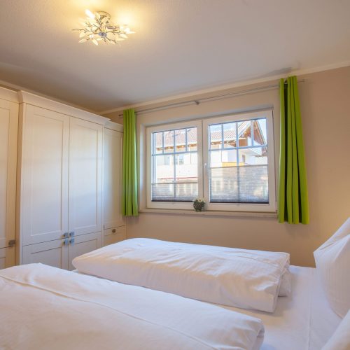 Doppelbett und Gardienen in grün in Ferienwohnung in Garmisch-Partenkirchen