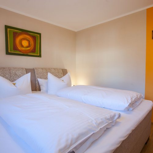 Doppelbett und Bild in Ferienwohnung in Garmisch-Partenkirchen