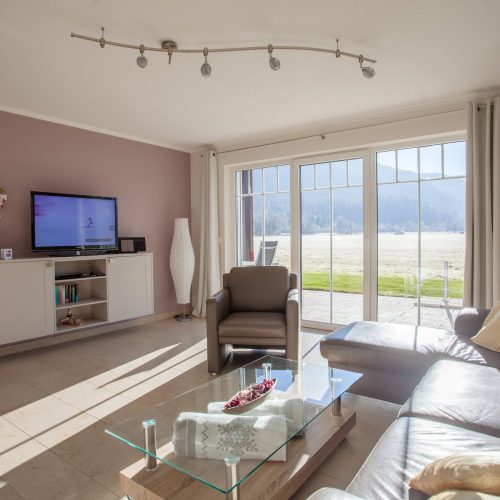 Wohnzimmer mit Fernseher und Sofa in Ferienwohnung in Garmisch-Partenkirchen