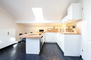 Küche in weiß mit dunklem Fußboden in Ferienwohnung in Garmisch-Partenkirchen