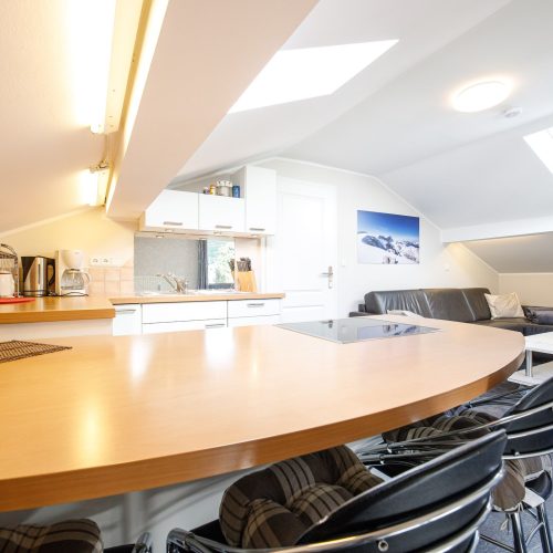 Esstisch mit Stühlen und offene Küche in Ferienwohnung in Garmisch-Partenkirchen