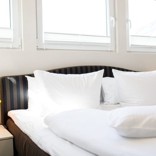 Doppelbett mit Nachttisch in Ferienwohnung in Garmisch-Partenkirchen