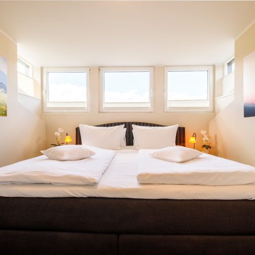 Doppelbett mit Bildern in Ferienwohnung in Garmisch-Partenkirchen