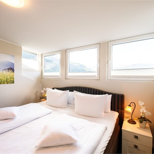 Doppelbett mit drei Fenster in Ferienwohnung in Garmisch-Partenkirchen