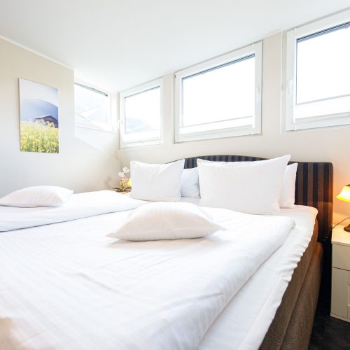 Doppelbett mit Nachttisch in Ferienwohnung in Garmisch-Partenkirchen